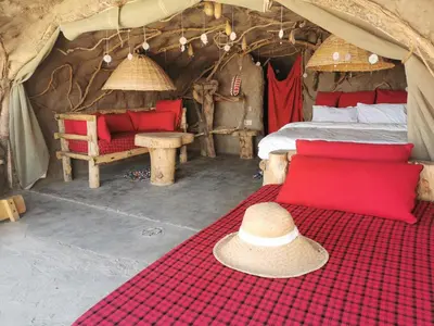 a hat is sitting on a bed in a tent at Maasai Sacred Site - Africa Amini Life in Ngare Nanyuki