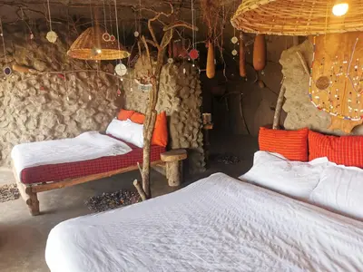 a bedroom with two beds in a room with a wall at Maasai Sacred Site - Africa Amini Life in Ngare Nanyuki