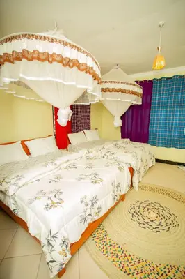 a bedroom with two beds and a rug at Kilimanjaro Kwetu Homestay in Moshi