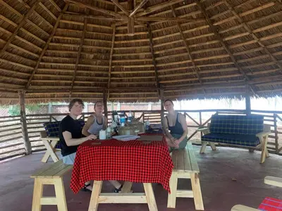 three people sitting at a table in a tent at Kilimanjaro Kwetu Homestay in Moshi