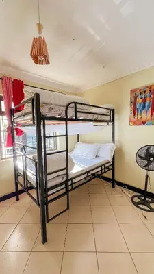 a bedroom with two bunk beds in a room at Kilimanjaro Kwetu Homestay in Moshi