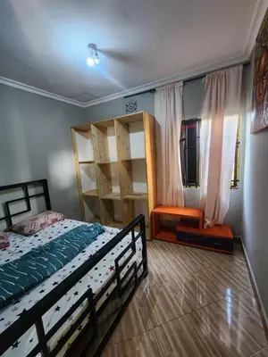 a bedroom with a bed and bunk beds and a chair at Hakuna Matata House in Arusha