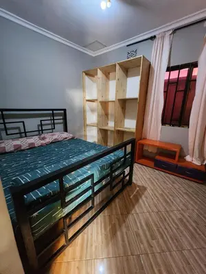 a bedroom with a bed and a book shelf at Hakuna Matata House in Arusha