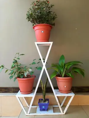 three potted plants sitting on a white shelf at Leadway Park Moshi Kilimanjaro in Moshi