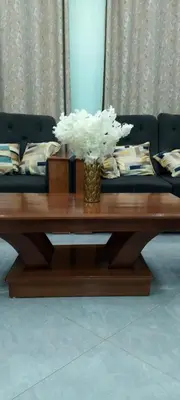 a coffee table with a vase of white flowers on it at Leadway Park Moshi Kilimanjaro in Moshi
