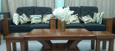 a living room with a couch and a vase of flowers on a table at Leadway Park Moshi Kilimanjaro in Moshi