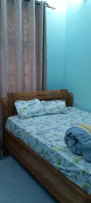 a bed with a wooden frame with a blanket on it at Leadway Park Moshi Kilimanjaro in Moshi