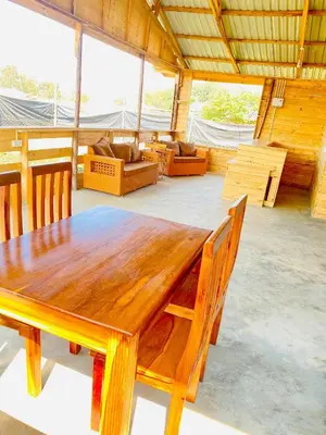 a wooden table and chairs in a room at Twende Home lodge in Arusha