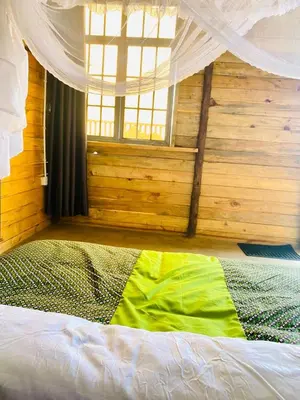 a bed in a room with a window at Twende Home lodge in Arusha