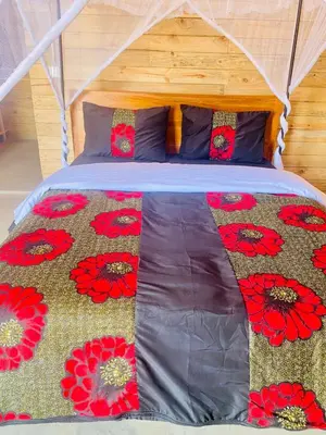 a bed with red flowers on it in a room at Twende Home lodge in Arusha
