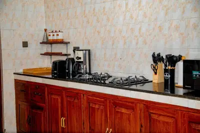 a kitchen with a stove and a counter top at The Nook at Njiro 39 - 3BR by Kyada Stays in Arusha