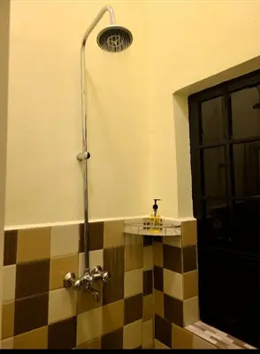 a shower in a bathroom with a checkered floor at Pumzika hill homes in Arusha