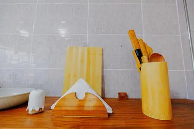 a wooden counter top with a vase with some knives at Serene and Amara By Tadre House's in Arusha
