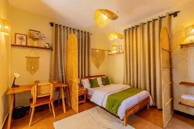 a bedroom with a bed and a desk and a table with a bed sidx sidx at Serene and Amara By Tadre House's in Arusha