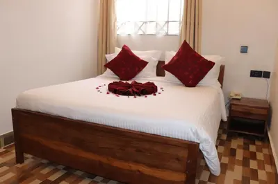 a bedroom with a bed with red pillows at Blue Junction Eco Lodge in Arusha