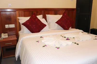 a bed with red and white flowers on it at Blue Junction Eco Lodge in Arusha