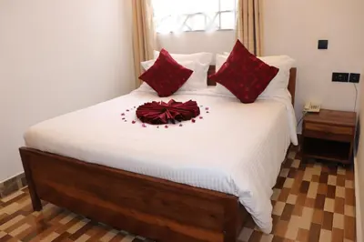 a bedroom with a large bed with red pillows at Blue Junction Eco Lodge in Arusha