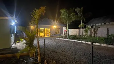 a house at night with palm trees in front of it at Shavia Home in Arusha