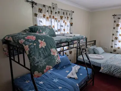 a bedroom with two bunk beds with blue sheets at Shavia Home in Arusha