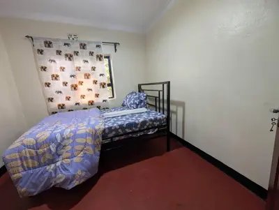 a bedroom with a bed with a comforter and a pillow at Shavia Home in Arusha