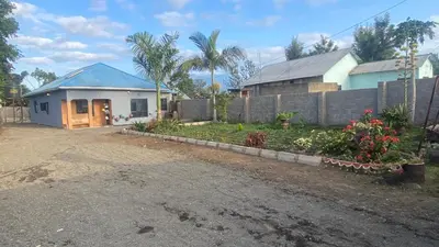 a house with a blue roof and a yard at Shavia Home in Arusha