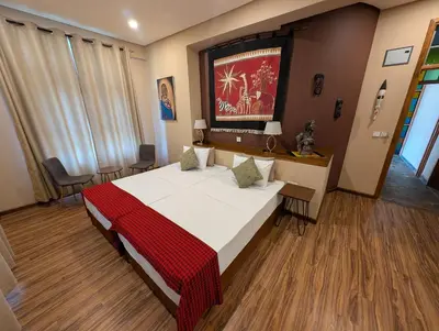 a bedroom with a large bed with a red blanket at Explorers Kilimanjaro Boutique Hotel in Moshi