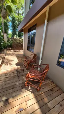 two chairs and a table on a wooden deck at Explorers Kilimanjaro Boutique Hotel in Moshi