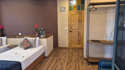a room with a bed and a desk and a door at Explorers Kilimanjaro Boutique Hotel in Moshi