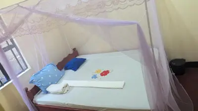 a small bed with a canopy in a room at Lake natron Naibala Bed&Breakfast in Mtowabaga