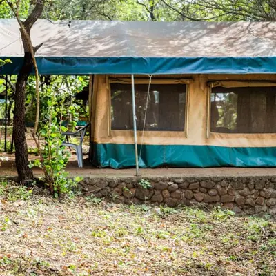 a house with a blue tarp on top of it at Havennature Safari Camp and Lodge in Namalulu