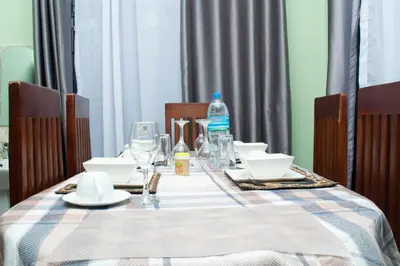 a table with plates and a bottle of water on it at Rest and Stay Minutes from Kilimanjaro Airport in Arusha