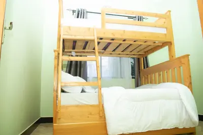 two bunk beds in a room with a ladder at Rest and Stay Minutes from Kilimanjaro Airport in Arusha