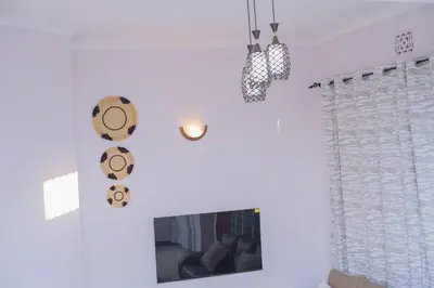 a living room with white walls and a fireplace at Sonia homes shared in Arusha