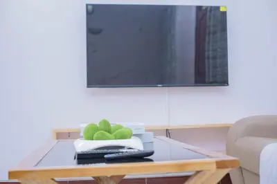 a glass coffee table with a television on top at Sonia homes shared in Arusha