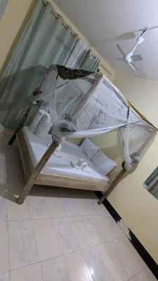 a bed is covered in plastic in a room at Kilimanjaroo Inn in Moshi