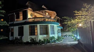 a house with a balcony on top of it at night at Kilimanjaroo Inn in Moshi
