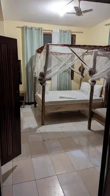 a bedroom with two beds and a ceiling at Kilimanjaroo Inn in Moshi