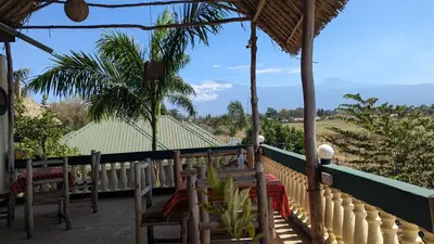 a porch with benches and a view of a field at Kilimanjaroo Inn in Moshi