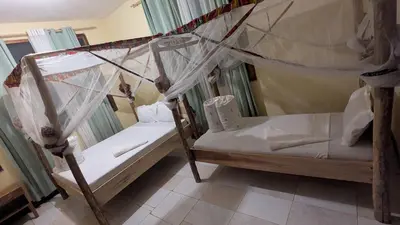 a bedroom with two bunk beds with mosquito nets at Kilimanjaroo Inn in Moshi
