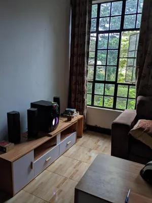 a living room with a tv on a stand with a large window at Banana Grove Retreat in Shiri