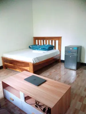 a bedroom with a bed and a desk with a laptop at Banana Grove Retreat in Shiri
