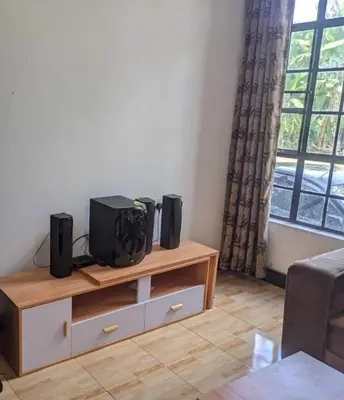 a living room with a table with speakers on it at Banana Grove Retreat in Shiri