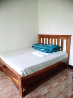a bed in a room with a wooden frame at Banana Grove Retreat in Shiri