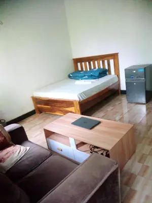 a living room with a couch and a bed at Banana Grove Retreat in Shiri