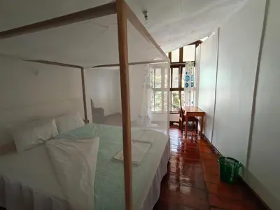 a bedroom with a canopy bed and a desk at Arusha Garden Home - Antique Villa in Arusha