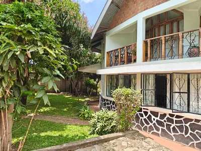 a house with a tree in front of it at Arusha Garden Home - Antique Villa in Arusha