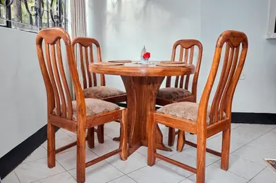 a wooden table with four chairs and a table with a bowl at Arusha Garden Home - Antique Villa in Arusha
