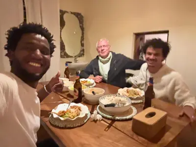 a group of three men sitting at a table with food at Bomani House in Arusha