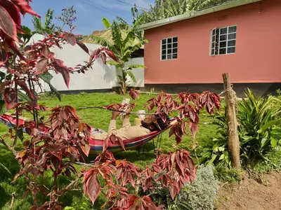 two people in a hammock in a yard next to a house at Bomani House in Arusha
