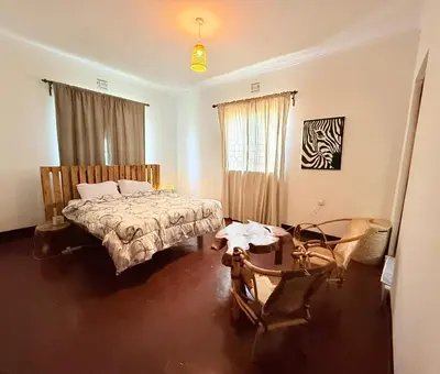a bedroom with a bed and a table in it at Bomani House in Arusha